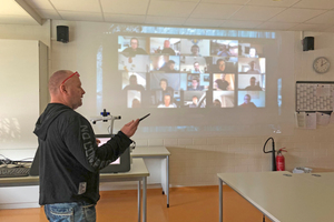  Im virtuellen Klassenraum sind die Schüler auf der Leinwand zu sehen.  
