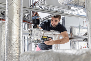  Abbildung 1: Ein Wissenschaftler überprüft das Steuersignal für ein Mischventil am Wärmepumpendampf­modul des Fraunhofer ISE. 