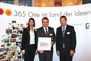  Ariane Derks vom Land der Ideen und Rainer Grähling von der Deutschen Bank (rechts) überreichen Dr. Walter Angelis von Ziehl-Abegg die Tafel „Ausgewählter Ort 2012“. 
